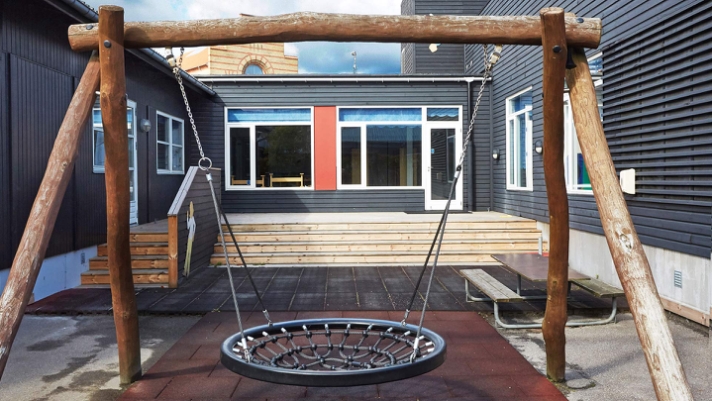 Udendørsarealer med plads til leg med trappe, gelænder og terrasse i modificeret fyrretræ..