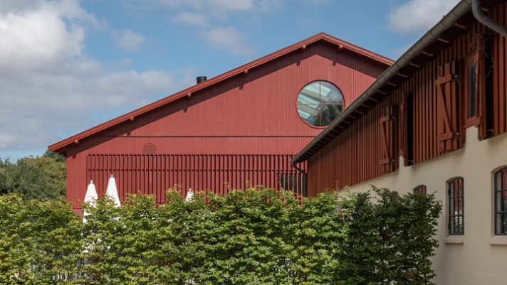 På Aggersvold Gods forvandles en historisk stald til eksklusive rammer, hvor dybrøde ThermoWood profiler i ask og fyr skaber karakter.